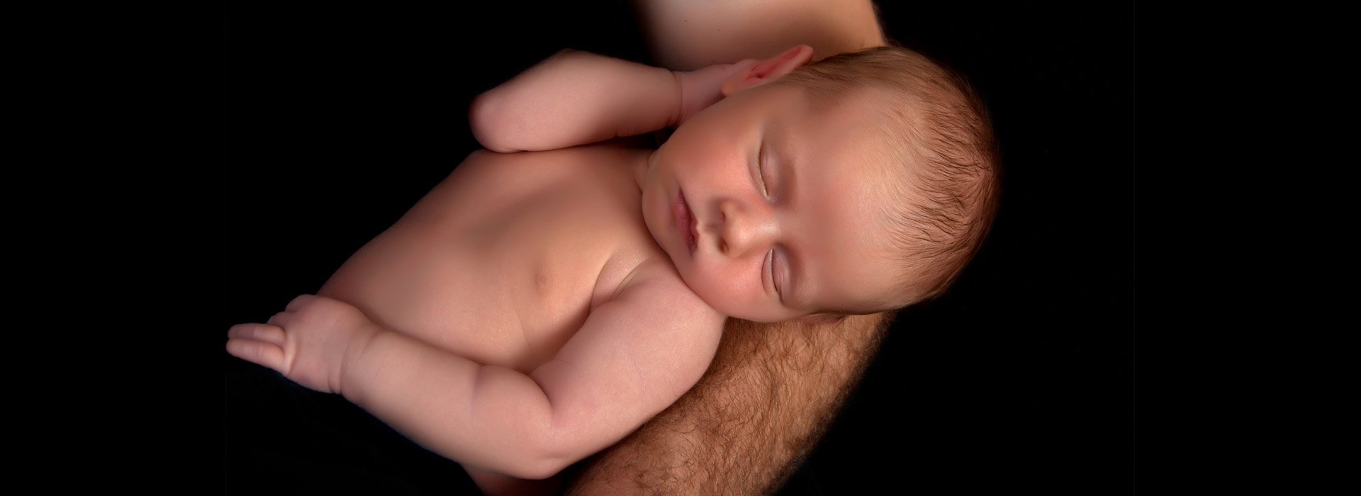zdjęcie noworodka na ręku ojca
